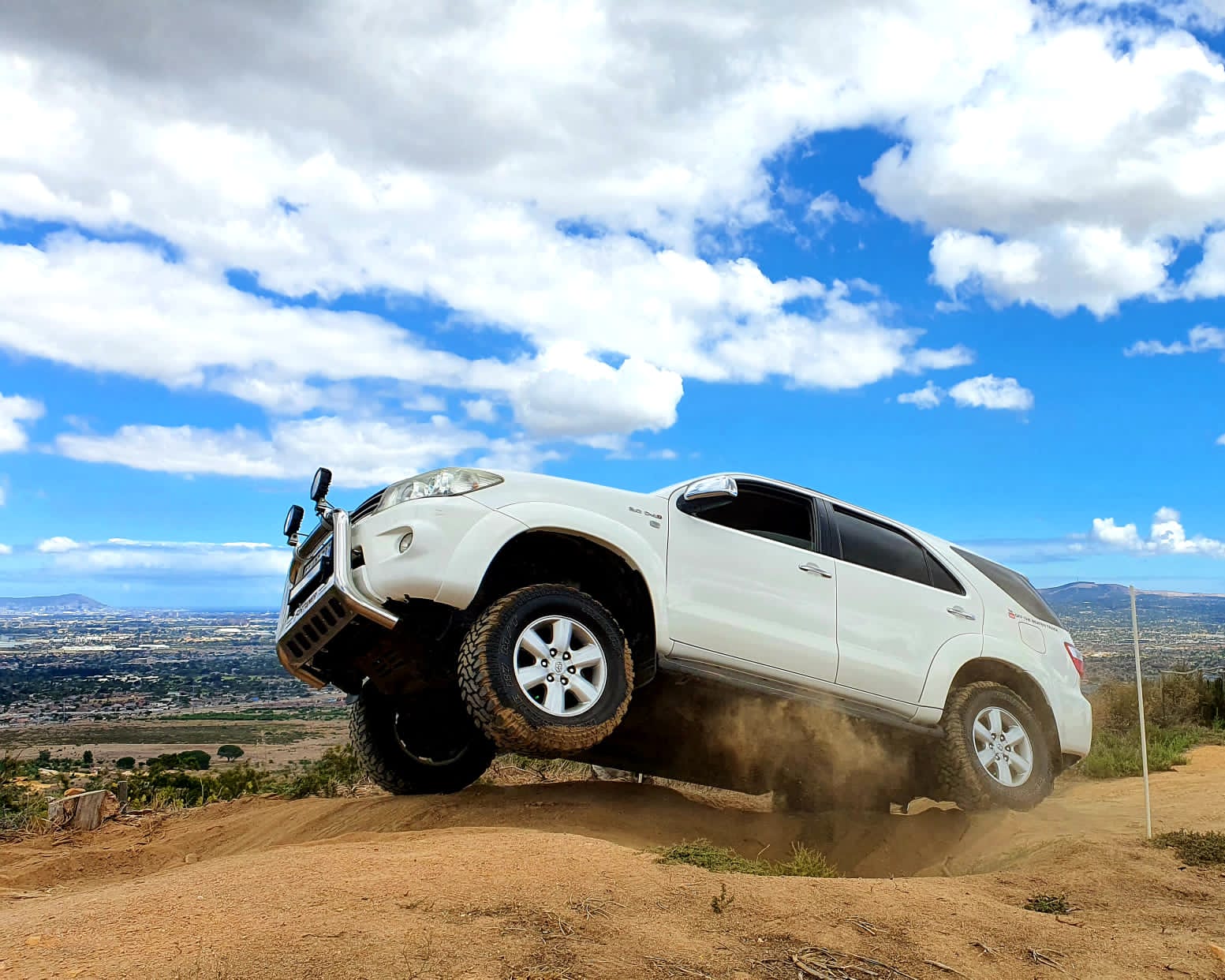 Toyota Fortuner cresting a steep sandy hill at Zevenwacht — front wheels lifting