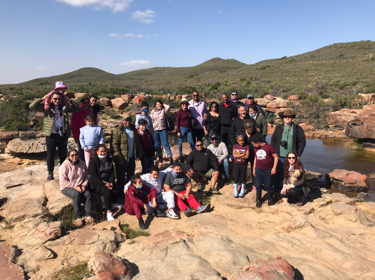 The full group at the waterfall — everyone out of the cars