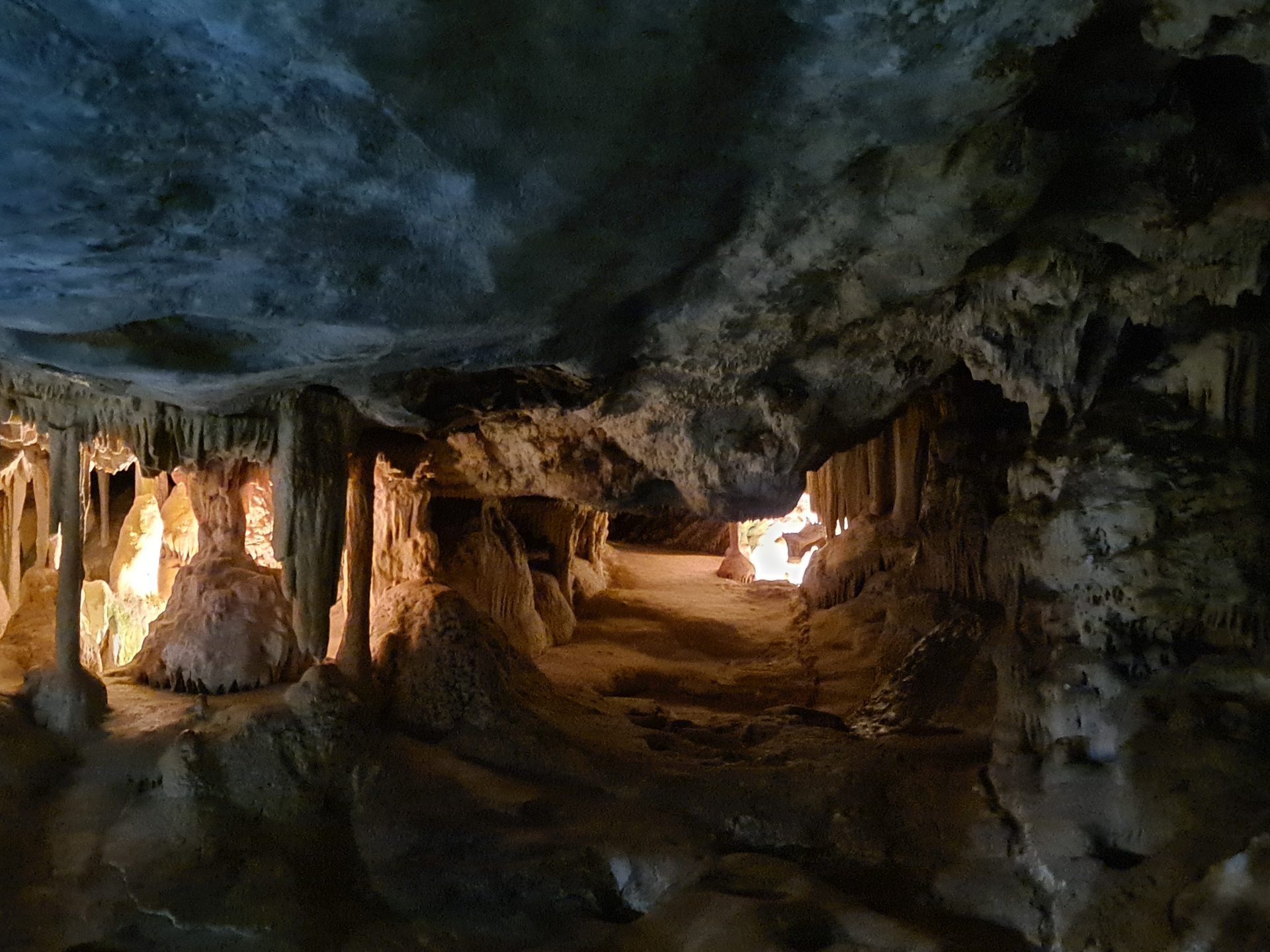 Inside one of the deeper sections — lit columns and draped formations