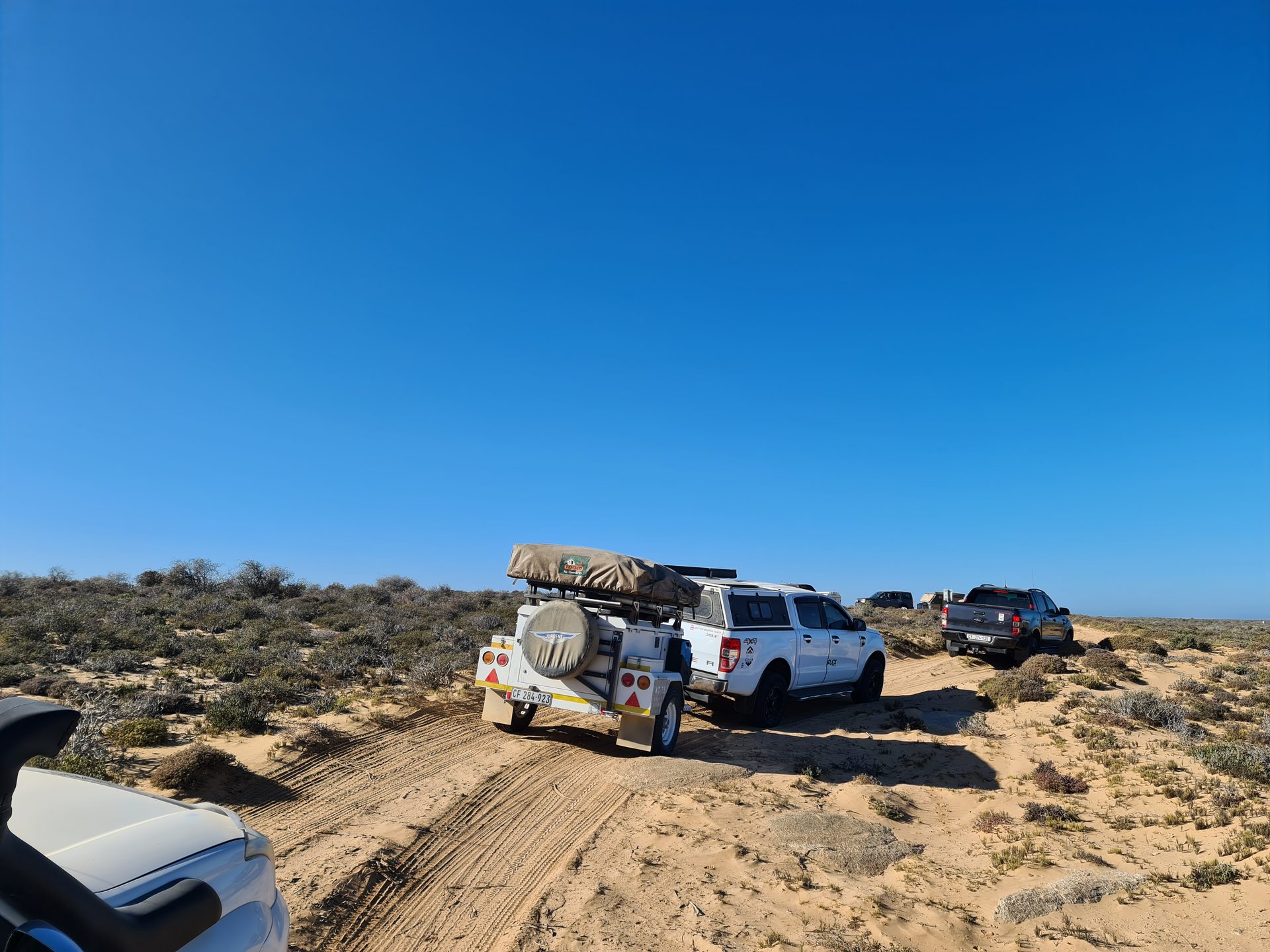 The convoy making its way along the sandy coastal track