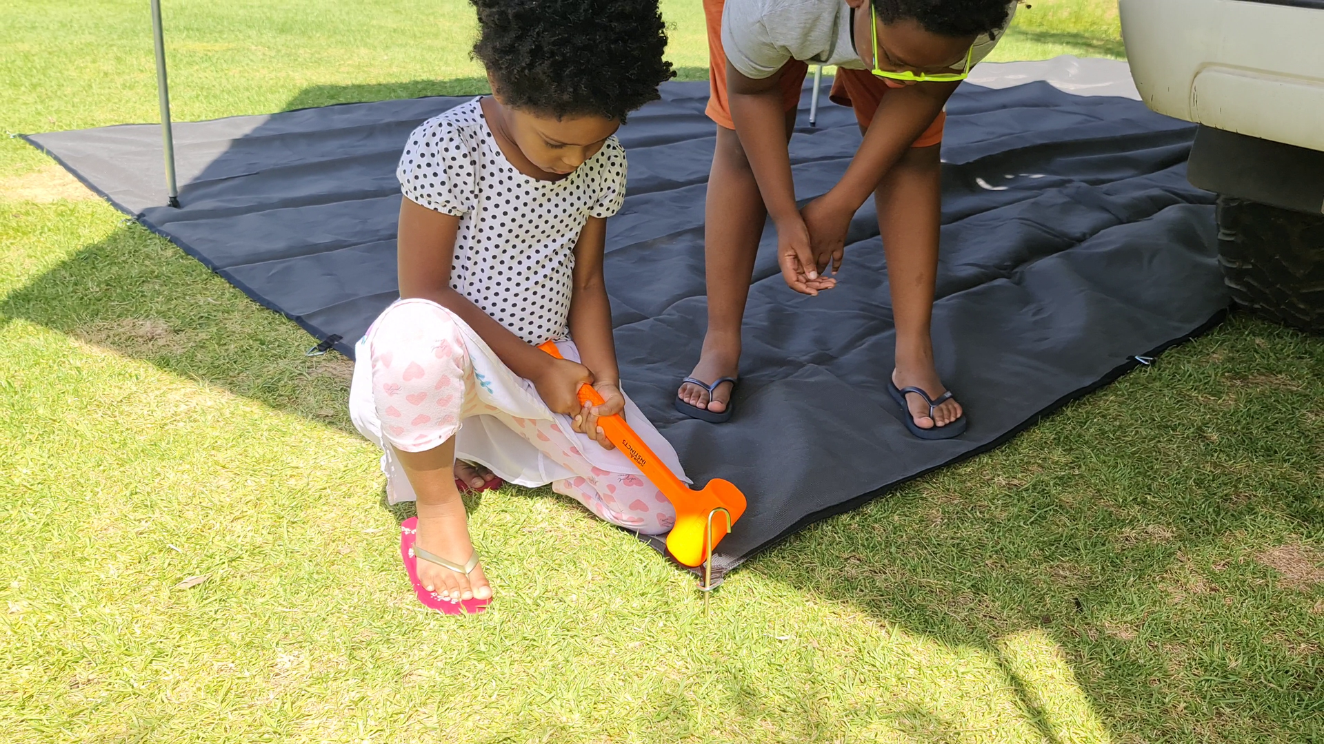 Children helping to set up Sarabi on the grass campsite