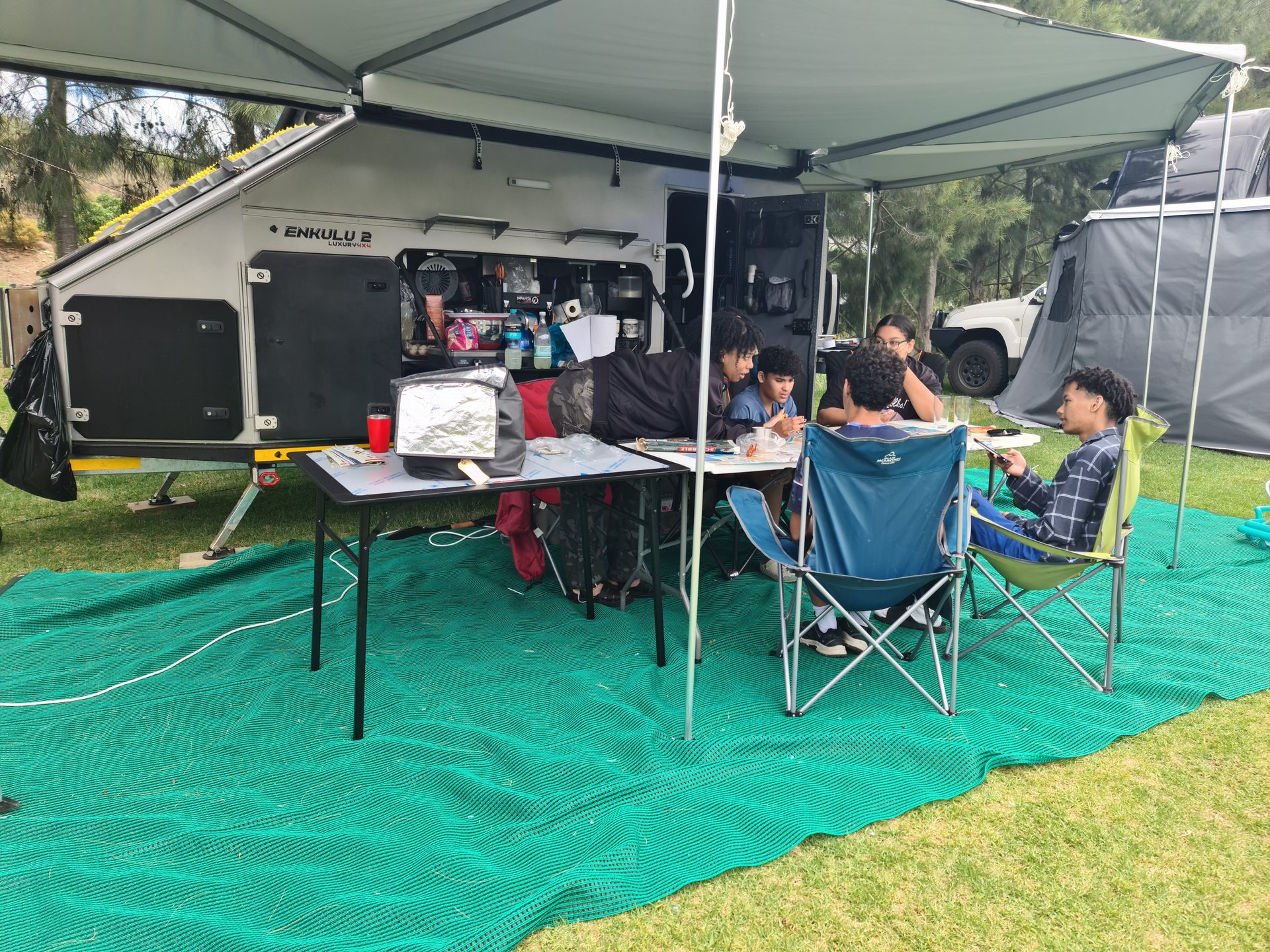The established camp kitchen and family table under the awning