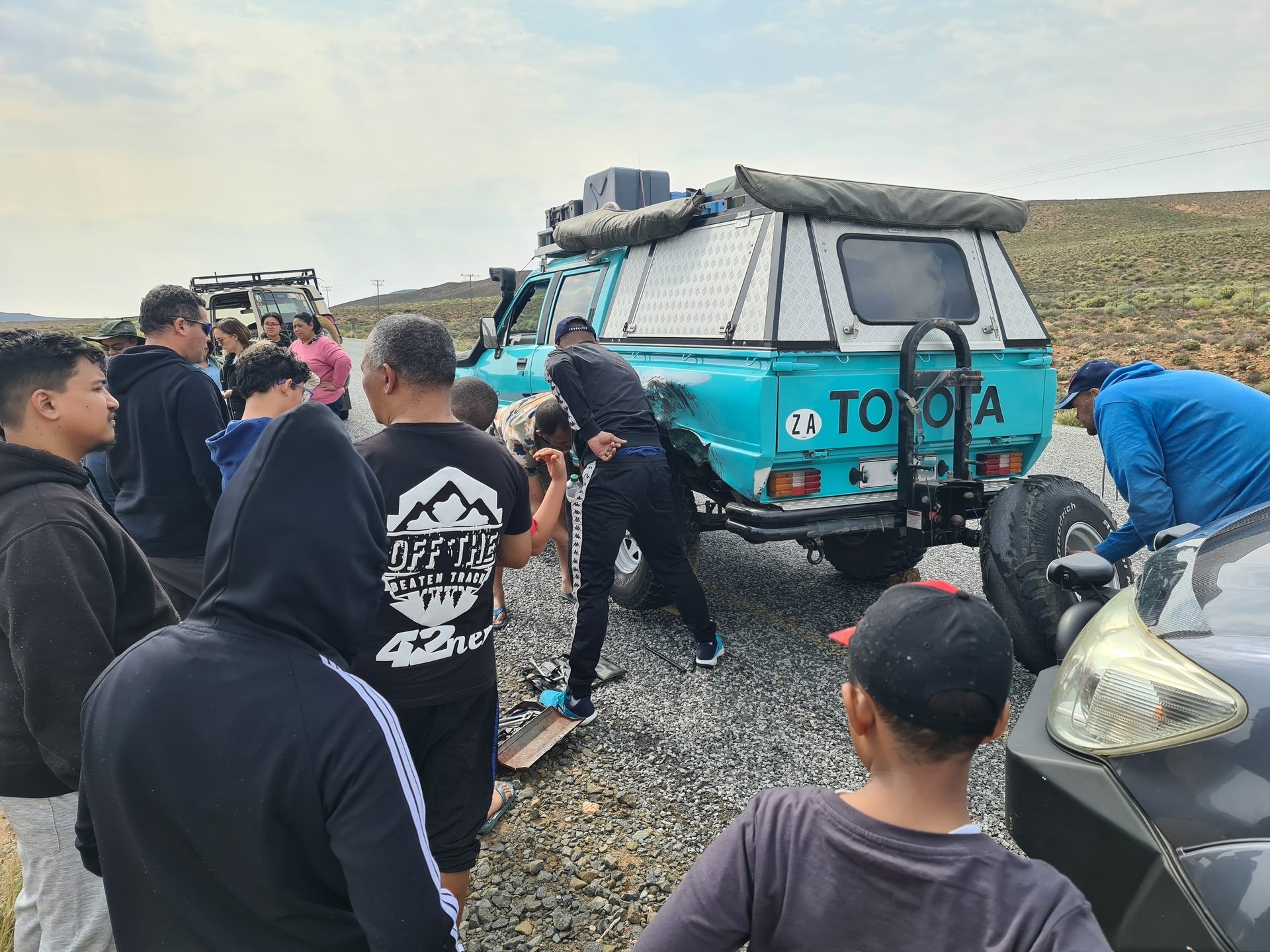 The group gathered around a vehicle during a roadside stop
