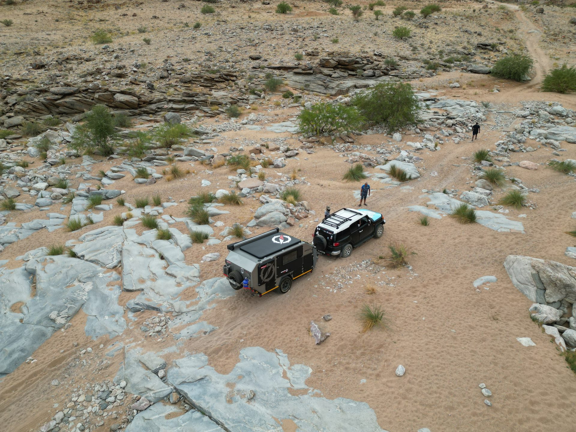 The convoy following the track through a wide desert valley