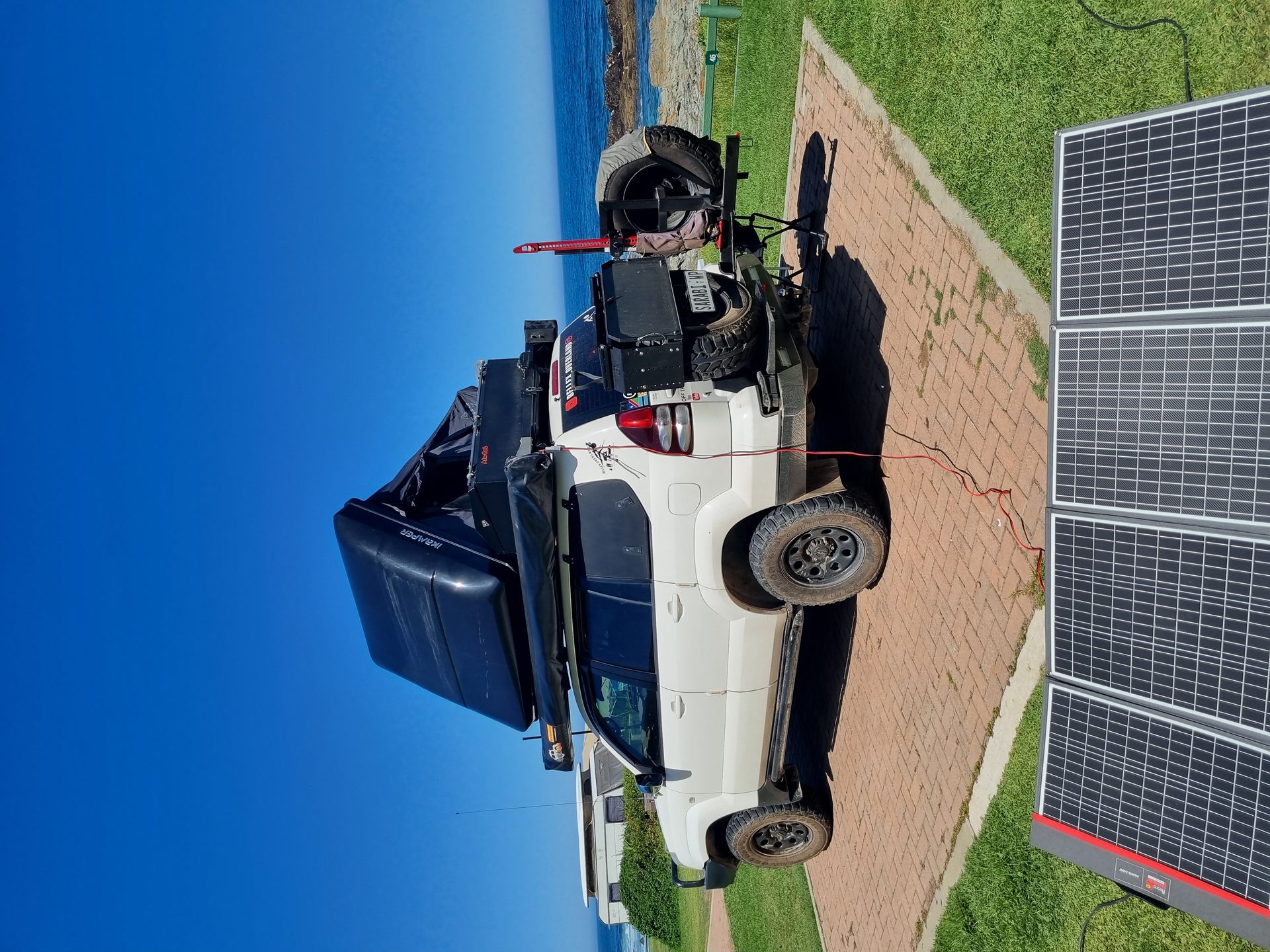 Sarabi set up beside the ocean with solar panels deployed