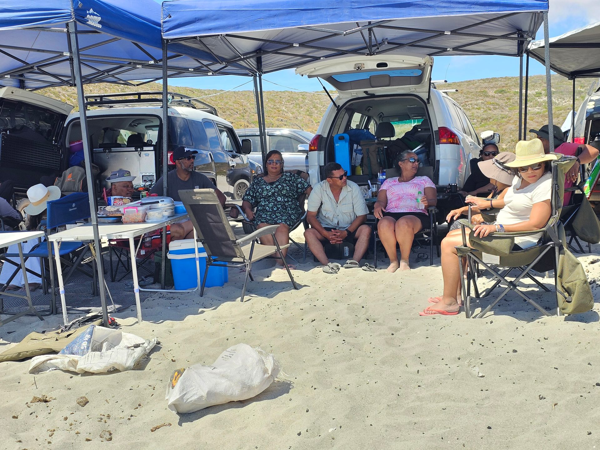 Awnings and vehicles make a comfortable base on the beach